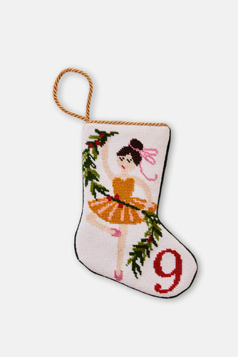 Hand-stitched stocking with ballerina in orange tutu and pink bow on white background