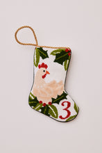 Needlepoint stocking featuring a hen with green holly accents on white backdrop