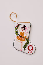 Hand-stitched stocking with ballerina in orange tutu and pink bow on white background