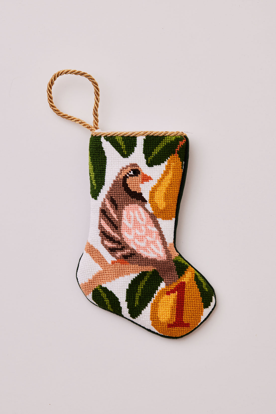 Needlepoint stocking featuring a partridge perched in a pear tree and green leaves on a white backdrop