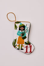Hand-stitched Christmas stocking featuring piper in yellow and blue outfit with holly leaves on white backdrop