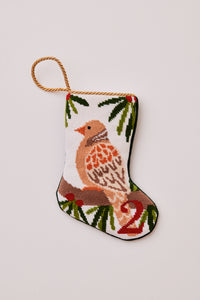 Needlepoint stocking featuring a turtle dove perched on greenery on a white setting