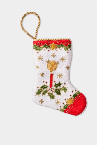 Christmas stocking with red, green, and white accents, featuring a holiday candle design with holly leaves and festive decorations