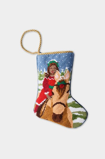 Christmas stocking with woman riding horse through snowy landscape