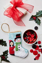 Bauble Stockings styled with red bow, holly sprigs, and festive red and black ornaments