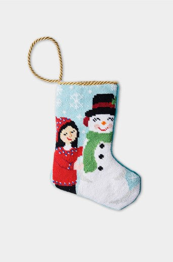 Hand-stitched Christmas stocking with smiling snowman and girl in red coat against snowy blue backdrop
