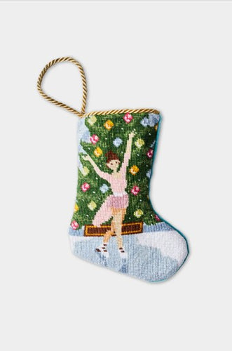 Hand-stitched stocking with ice skater in pink dress, icy rink, and ornamented evergreen tree