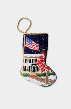 Hand-stitched needlepoint stocking with snowy house, waving American flag, and night sky