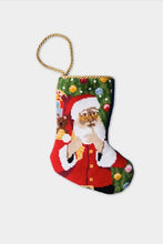 Hand-stitched Christmas stocking with Santa holding gifts in red suit and green ornamented background
