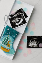 Let It Snow stocking displayed beside ultrasound photo for a sentimental holiday reveal