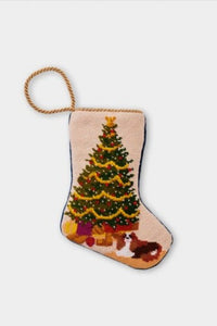 Needlepoint Bauble Stockings featuring a decorated Christmas tree with festive gifts and a dog sitting at the tree