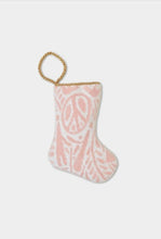 Hand-stitched needlepoint stocking with pink signs and pattern on soft white background