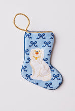 Hand-stitched needlepoint stocking featuring a white dog sitting with bows on a blue backdrop