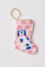 Hand-stitched needlepoint stocking featuring a white and blue dog sitting with bows on a pink background