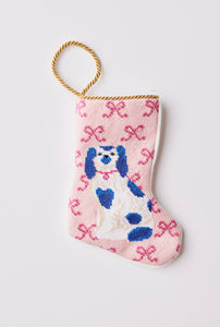 Hand-stitched needlepoint stocking featuring a white and blue dog sitting with bows on a pink background