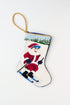 Christmas stocking featuring Santa skiing down a snowy hill with a red outfit against a snowy background