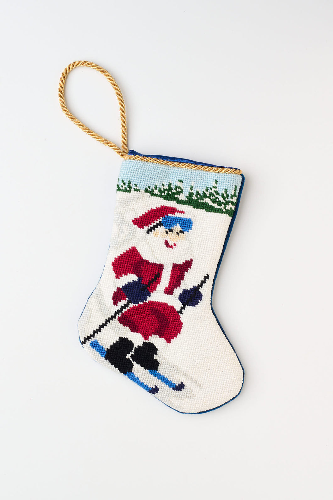 Christmas stocking featuring Santa skiing down a snowy hill with a red outfit against a snowy background