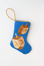 Needlepoint Bauble Stockings featuring spinning dreidels against a blue background