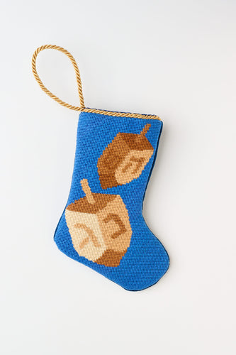 Needlepoint Bauble Stockings featuring spinning dreidels against a blue background