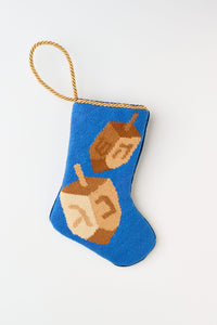 Needlepoint Bauble Stockings featuring spinning dreidels against a blue background