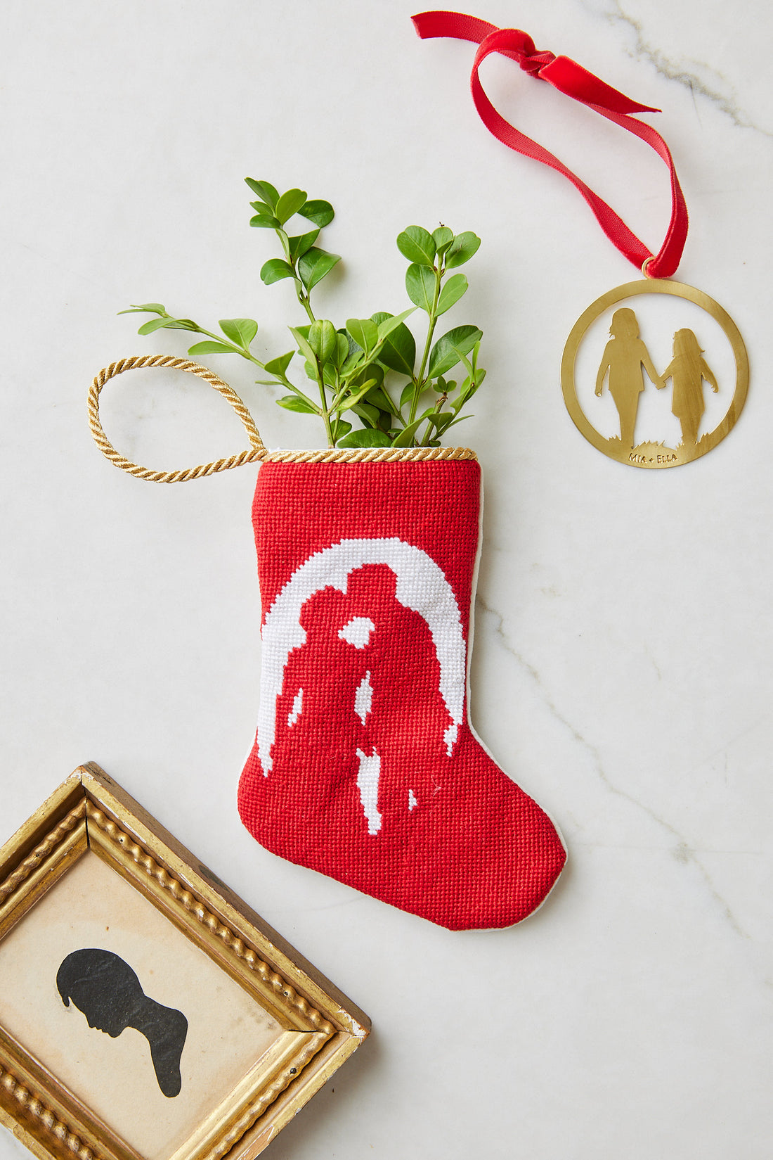 Bauble Stockings styled with gold decor and festive greenery on light backdrop